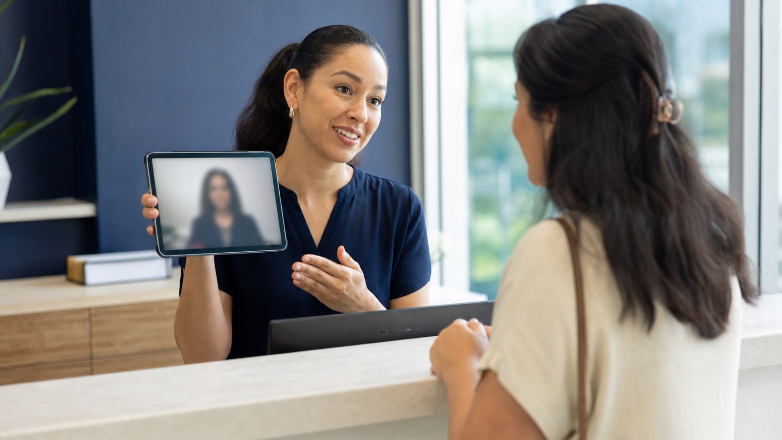 Healthcare receptionist using video remote interpreting on a tablet to assist a patient